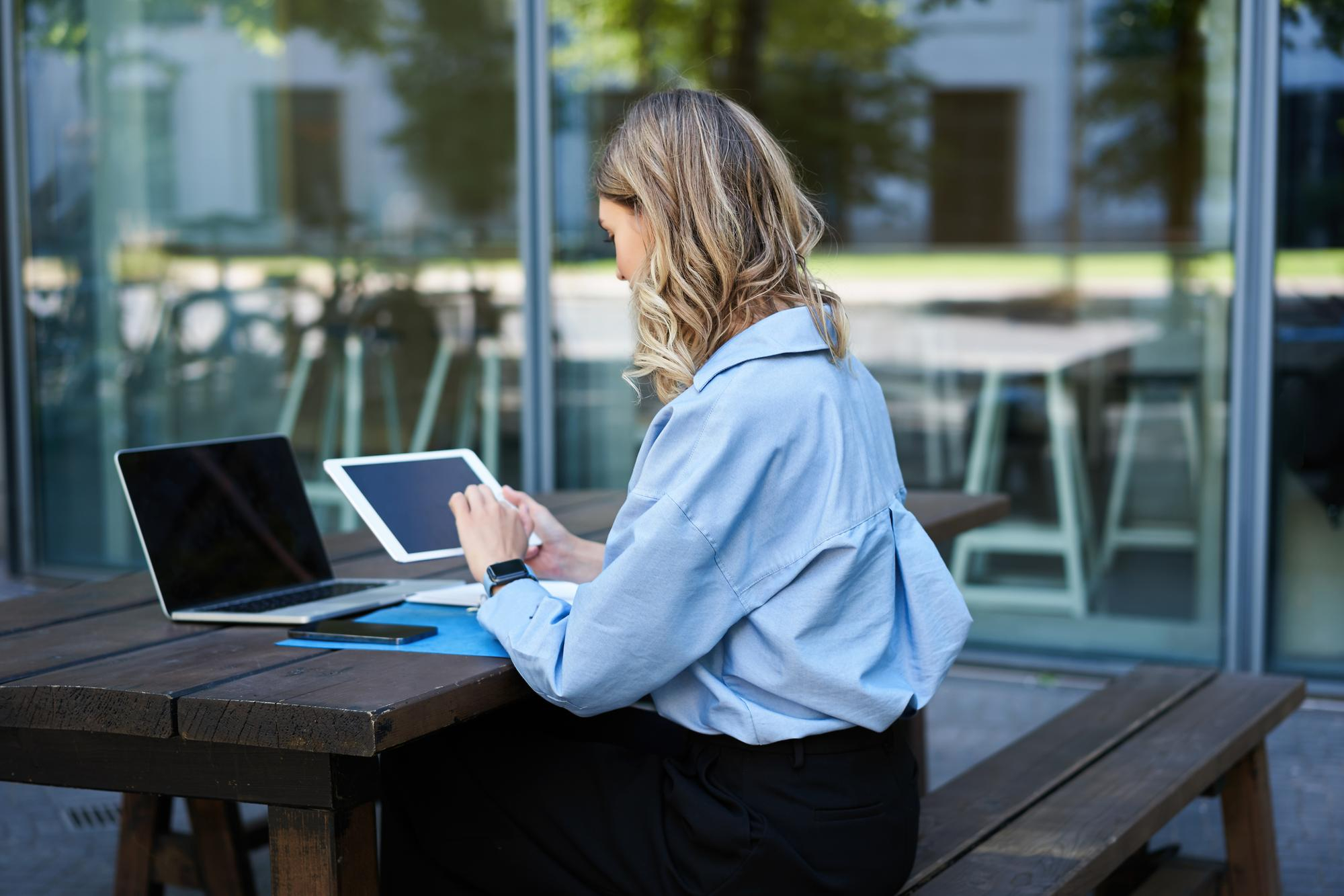 portrait-businesswoman-working-digital-tablet-checking-diagrams-sitting-outdoors-fresh-air